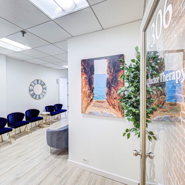 Anchor Therapy door open leading into waiting room with blue chairs against the wall.