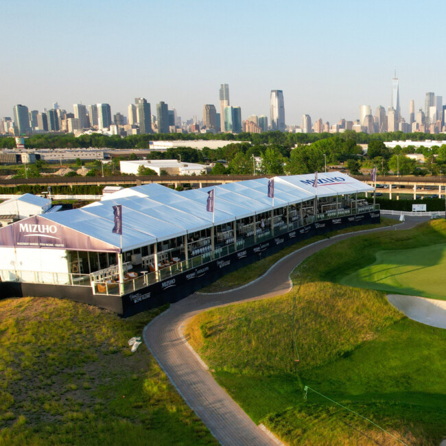 Aerial view of LPGA course in the day time with a white tent and the Manhattan skyline in the background