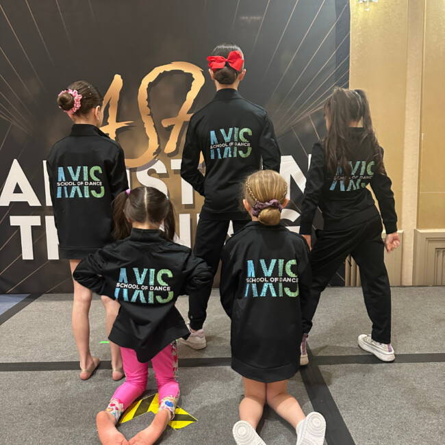 Five girls with their backs to the camera wearing AXIS School of Dance Jackets