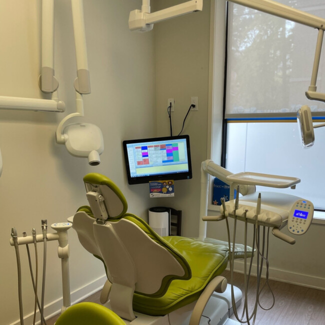 Patient room at Lucas Dental Associates with a green chair and dental equipment