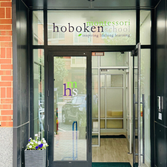 Exterior view of Hoboken Montessori school with glass door open and flower planter outside