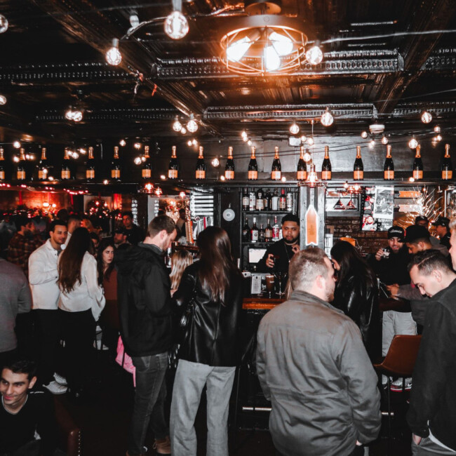 A view of the The Waiting Room with people standing around the bar