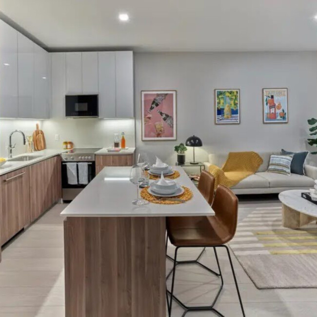 Kitchen and living room in Fiat House with an island and brown bar seats