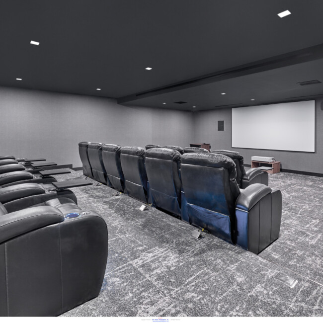 Cinema in Fiat House with black leather recliners and projector screen