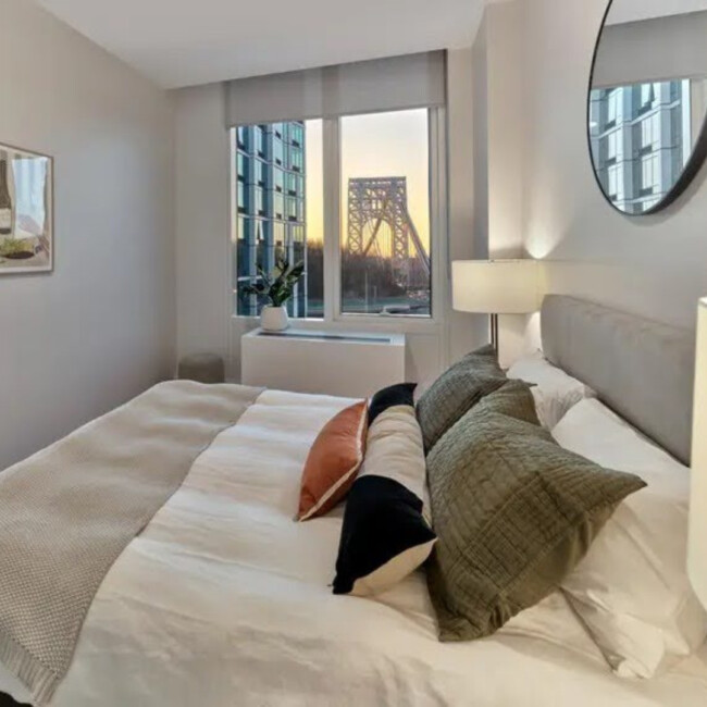 Bedroom in Fiat House with a window view of the George Washington Bridge and the sunrise