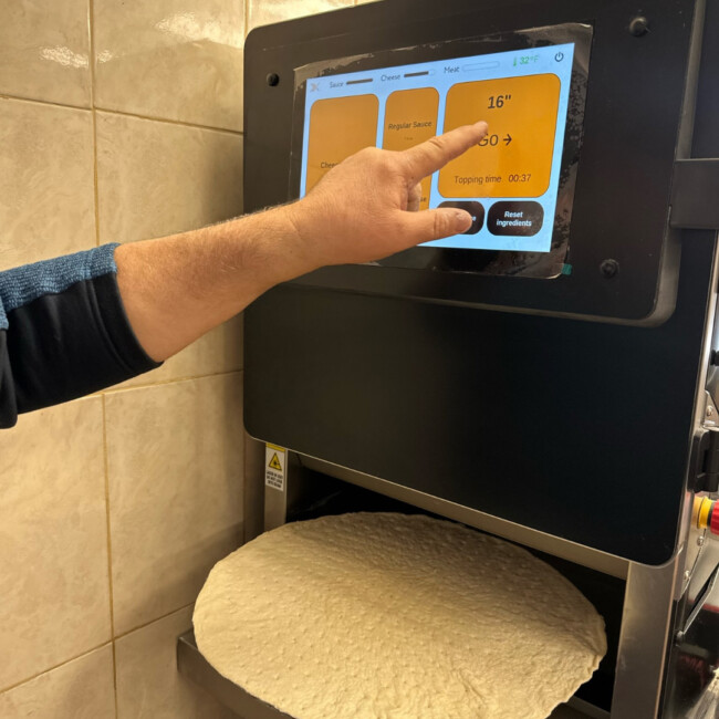 Hand touching pizza robot